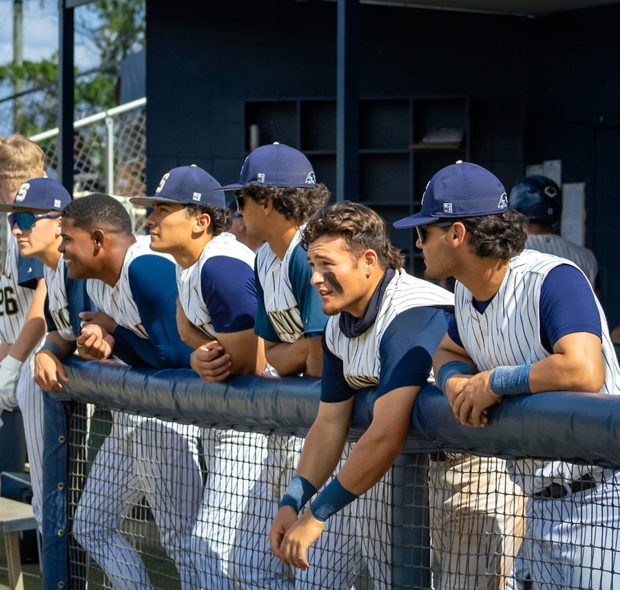Nic Pepe and Seminole State teammates leaning over dugout railing