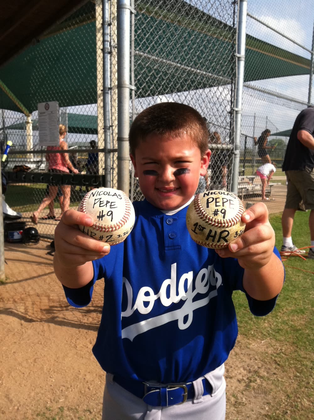 Young Nicolas Pepe holding 1st and 2nd HR baseballs